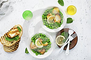 Green young peas, cheese haloumi, lemon. orange salad with slices of bread. Top View photo