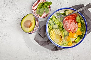 Green zucchini noodles salad with tomatoes, avocado and basil. H