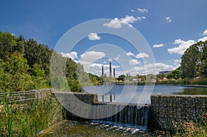 Greenery of Wetland in cloudy day with water pond view and brick kilns and chimneys at Sydney Park, Australia.