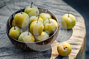 Greengage fruit in bowl on wooden table