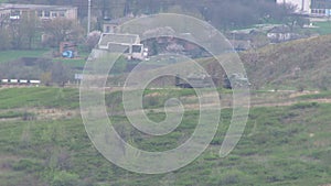 Greengrass landscape, road across the country. Tractor carries armored vehicles