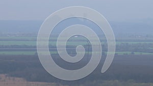 Greengrass landscape, trees and couple of slagheap in fog