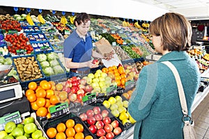 Greengrocer serving a customer photo