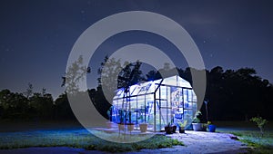 Greenhouse with lights on a starry night