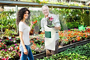 Greenhouse worker giving plants to a customer