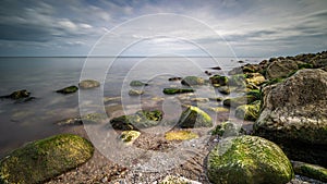 Greenish rocks in the shallow waters of Ope Cove, Isle of Portland, England