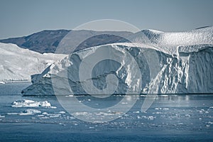 Greenland. The biggest glacier on a planet Jakobshavn. Huge icebergs of different forms in the gulf. Studying of a