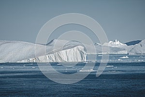 Greenland. The biggest glacier on a planet Jakobshavn. Huge icebergs of different forms in the gulf. Studying of a