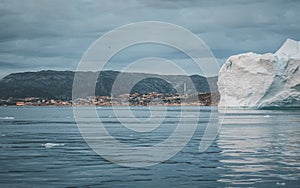 Greenland Glacier with Sea Ice and huge iceberg in front of arctic city of Ilulissat. Glacial Landscape near the famous