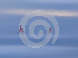 Greenland Ilulissat glaciers at ocean with red sailing boat in fog