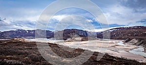 Greenlandic wastelands landscape with river and mountains in the background, Kangerlussuaq, Greenland