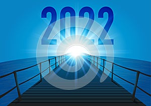 Greeting card 2022 with a pontoon over the sea directed towards the sun at the horison.