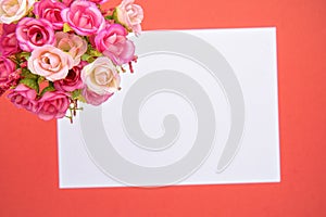 Greeting card bouquet of small roses with a white note, orange background. St. Valentine`s Day