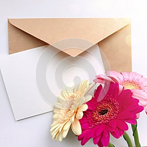 Greeting card concept with envelope and gerbera flower. Blank paper postcard, vintage envelope and gerbera flowers