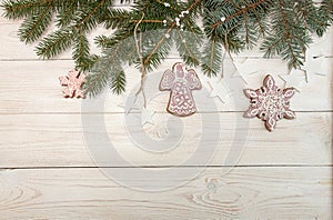 Greeting card with decor gingerbread cookies snowflakes, fir tree branch on white wooden background. Overhead of Christmas New Ye