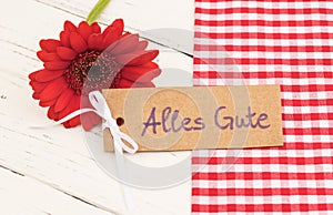 Greeting card with german text, Alles Gute, means best wishes with red flower decoration