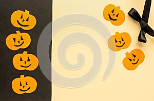 Greeting card for halloween. Paper pumpkins on beige and black background, copyspace