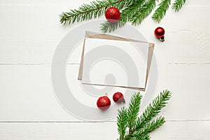 Greeting card mockup with red christmas decorations and fir tree branches on white background