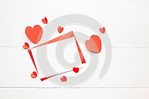 Greeting card mockup  white blank card with paper envelope and red parer hearts on wooden table background