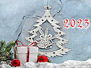 A greeting card for the new year 2023. Festive background. Christmas tree with bells.