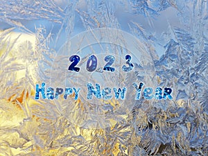 A greeting card for the new year 2023. Frosty patterns on the window. Christmas and New Year background for creativity.