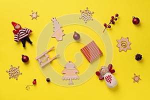 Greeting card for New year party. Christmas gifts, decorative elements and ornaments on yellow background. Top view, copy space.