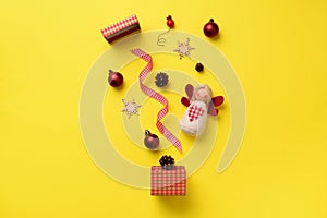 Greeting card for New year party. Christmas gifts, decorative elements and ornaments on yellow background. Top view. Winter