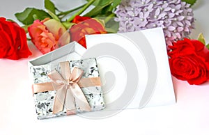 Greeting card with open giftbox with ribbon and bow on a white background with red roses
