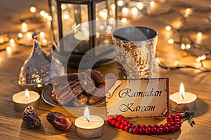 Greeting card Ramadan Kareem with dates, rosary, and metal water cup with Allah text in arabic