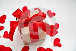 Greeting card with red hearts and a gift box on a white background. Valentine`s day holiday concept. Flat lay, copy space