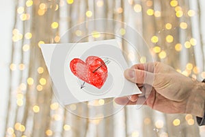 Greeting card with a red painted heart in the hands, a declaration of love on Valentine`s Day