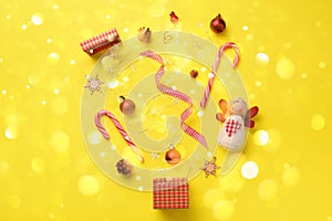 Greeting card with snow, lights bokeh for New year party. Christmas gifts, decorative elements and ornaments on yellow background