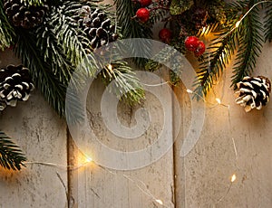 Greeting card template with fir tree twigs  pine cones  and vivid red berries on the wooden background