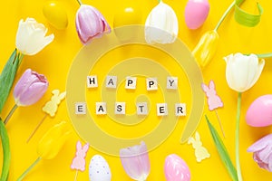 Greeting card with text HAPPY EASTER. Multicolored easter eggs and tulips on yellow background