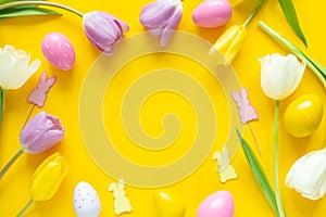 Greeting card with text. Multicolored easter eggs and tulips on yellow background. Copy space for your text