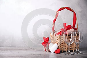 Greeting card Valentine`s day with hearts ,goblet and gifts in basket on wooden background. With space for your text greetings