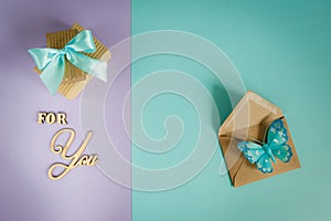 Greeting card for You on a purple - mint background with gift boxes, envelope and butterfly .