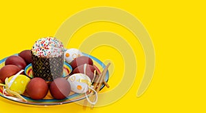 Greeting Easter background with a plate, painted Easter eggs, candles and willow branches. Concept of an Easter greeting