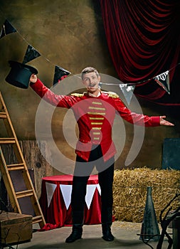 Greeting. Illusionist or showman. Happy excited man, retro circus entertainer announces start of show isolated over dark