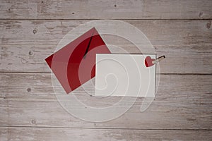 Greeting or invitation card mock up with red envelope on wooden background. Romantic Small hearts Valentine day. Blank