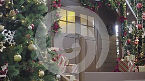 Greeting Season concept. Gimbal shot of ornaments on Christmas tree with decorative light and front home with door