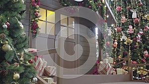 Greeting Season concept. Gimbal shot of ornaments on Christmas tree with decorative light and front home with door