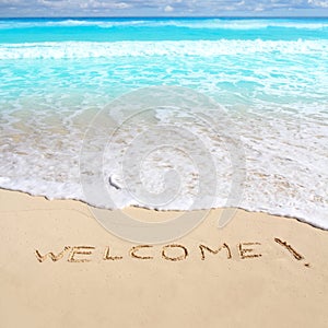 Greetings welcome beach spell written on sand photo