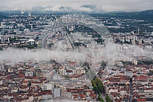 Grenoble cityscape, aerial view of Grenoble city with clouds and mountain background