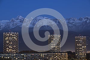 Grenoble, France, January 2019 : the three towers in front the belledonne mountains at night, ile verte neighbourhood