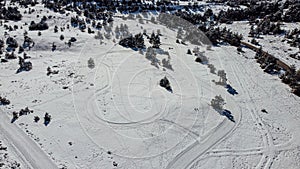 Greolieres ski slope and trees covered in snow, drone aerial view in winter