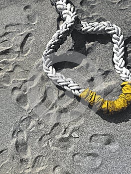 Grey beach with yellow ship rope