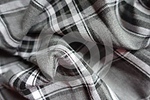 Grey, black and white flannel tartan fabric in soft folds