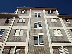 Grey brick building soars into blue sky