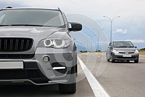 Grey modern car parked on asphalt road